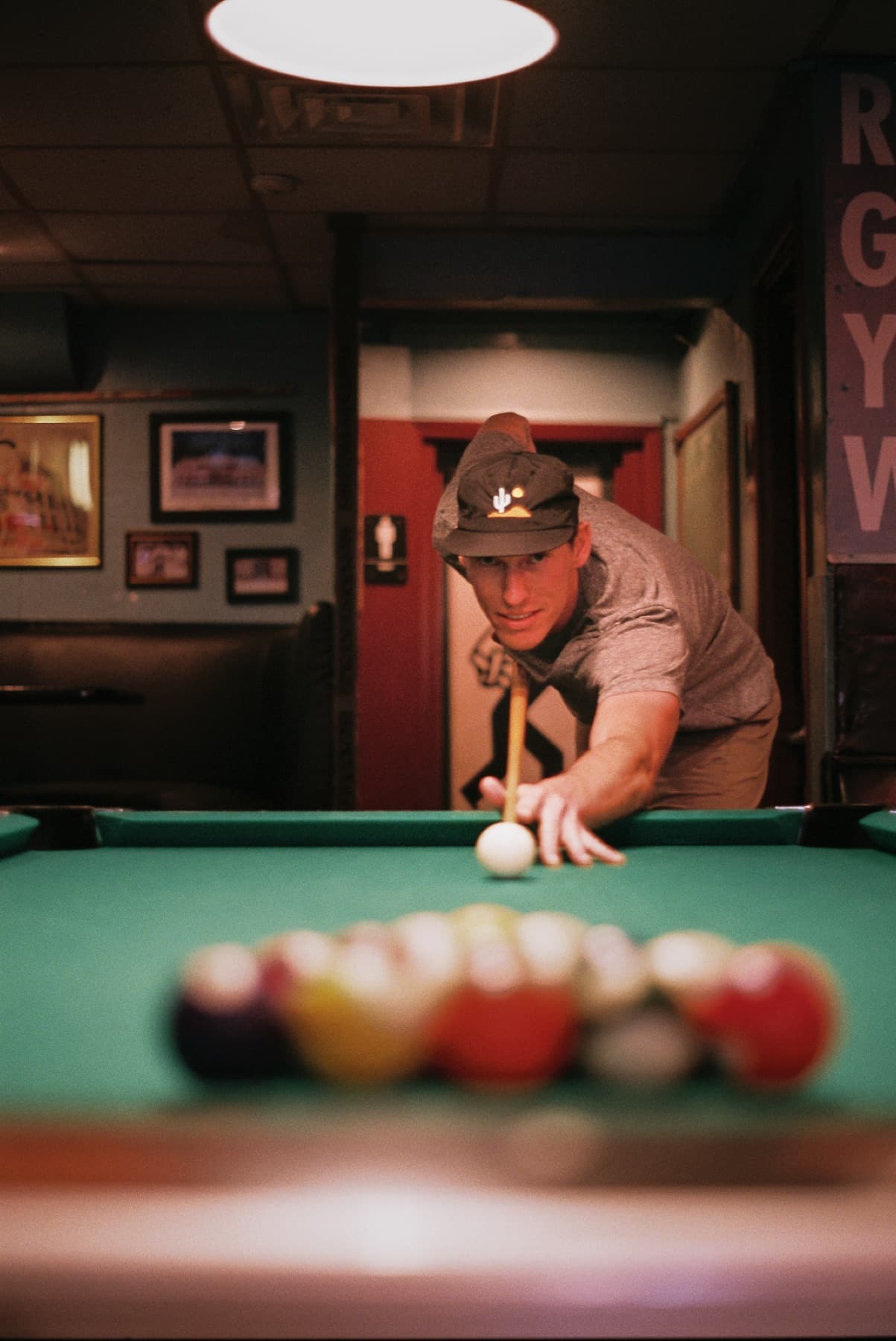 film photo man shooting pool from low perspective of pool table