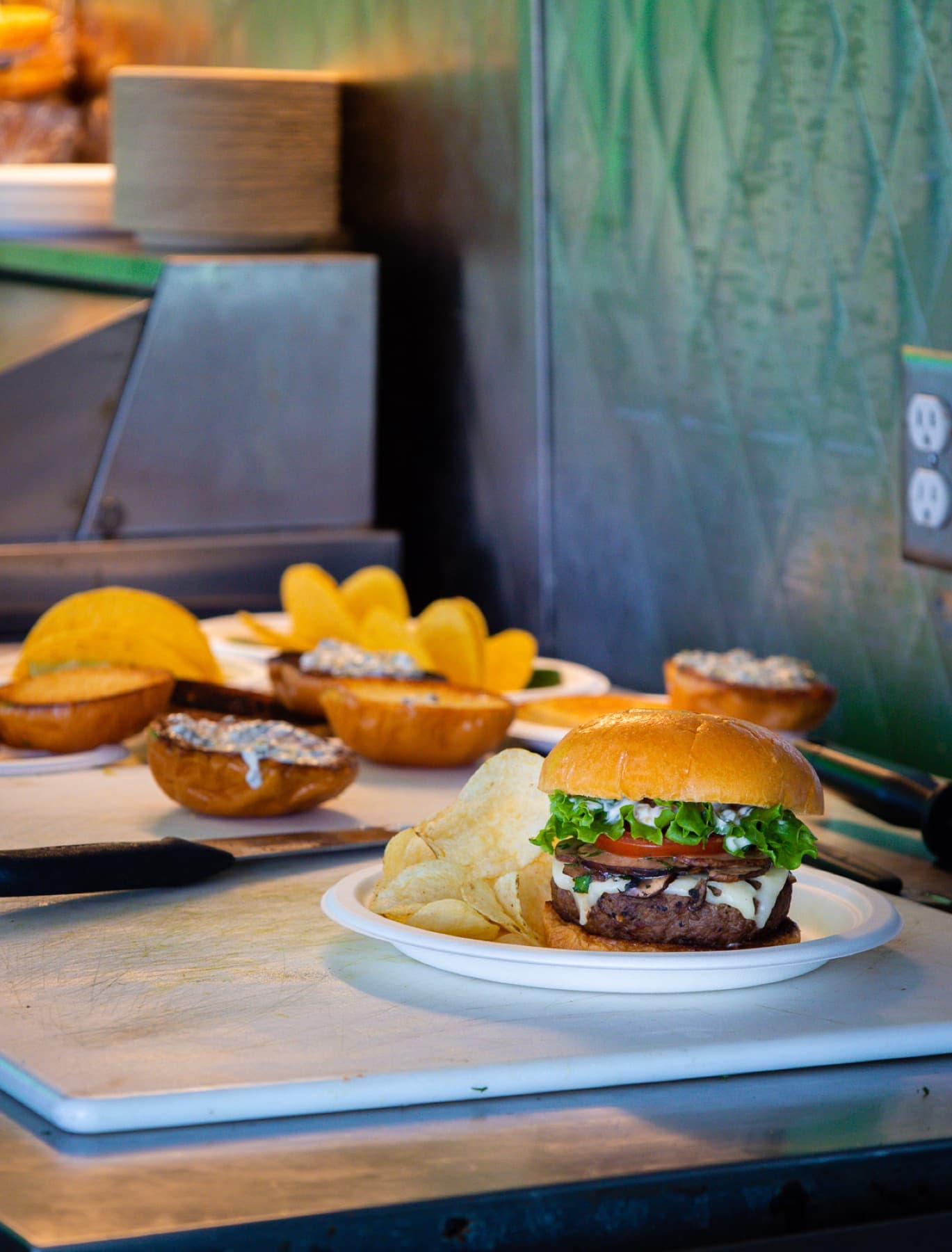 mushroom swiss burger with chips on food truck prep line