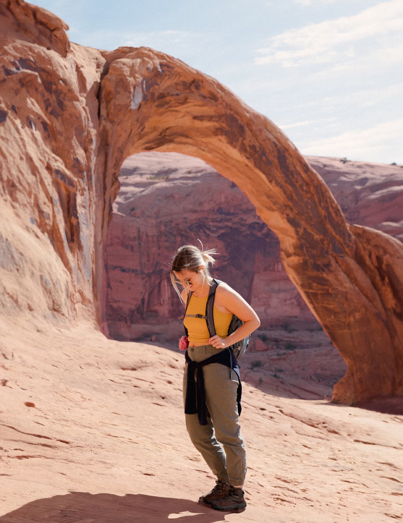 young woman posing in front of corona arch utah