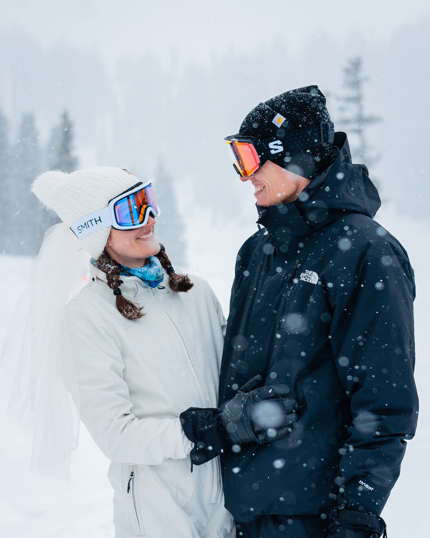 A couple smiling together at their snowy Colorado ski elopement