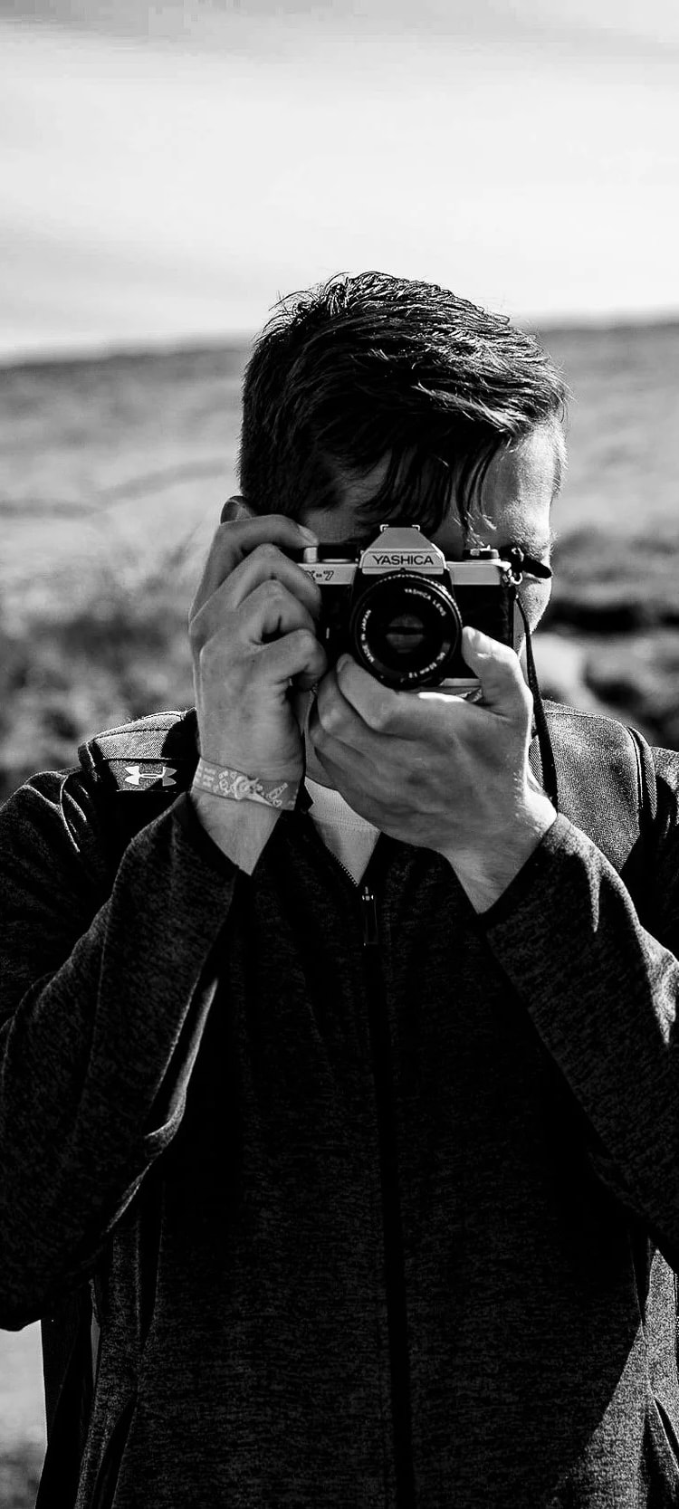Cullan McNamara taking a photo, black and white. Photo by Evan Mosley.